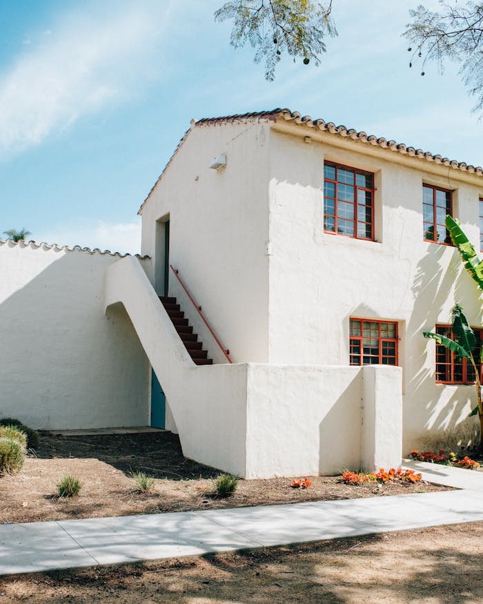old-white-cottage-house-in-sunlight-3771265 Spanish-style exterior with stucco walls and lush garden in Camarillo, California.